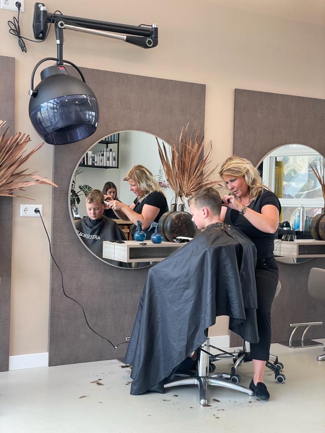 Stylist knipt het haar van een klant bij Styling by M